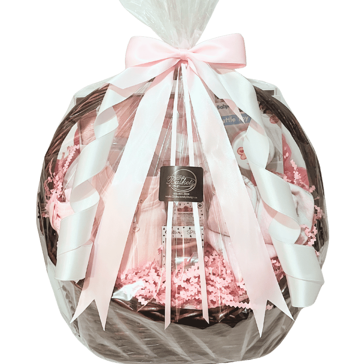 Baby Essentials Premium gift basket in pink, wrapped in cellophane with ribbon, featuring baby bath items, blanket and grooming accessories in a keepsake basket