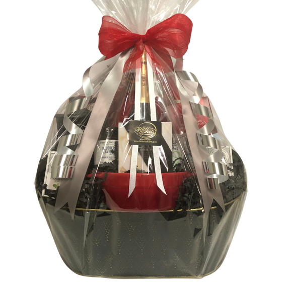 Comforts of Home Gift Basket with white marble brie baker, brie, camembert, coffee, pasta, salmon, honey, and gourmet treats, wrapped in cellophane with ribbons and bows.