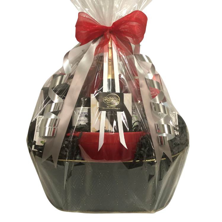 Comforts of Home Gift Basket with white marble brie baker, brie, camembert, coffee, pasta, salmon, honey, and gourmet treats, wrapped in cellophane with ribbons and bows.