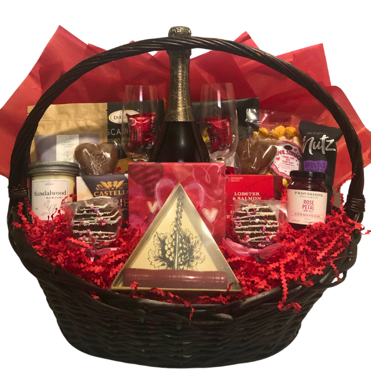 A gift basket containing various gourmet food items, spa items, wine and wine glasses, neatly arranged in a wicker basket with a beautiful red romantic colour scheme.