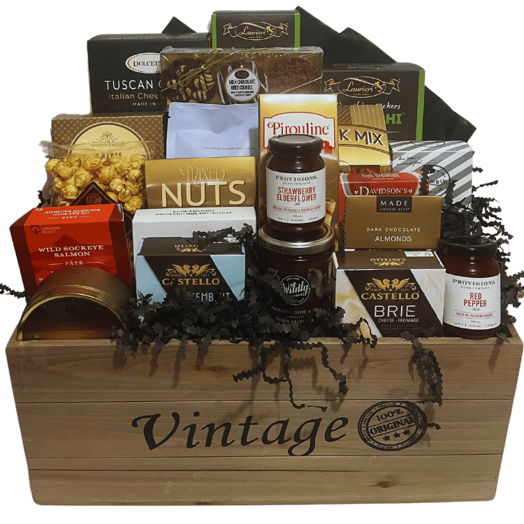 Vintage-style wood crate filled with gourmet snacks, cheese, chocolate, coffee, and savoury treats