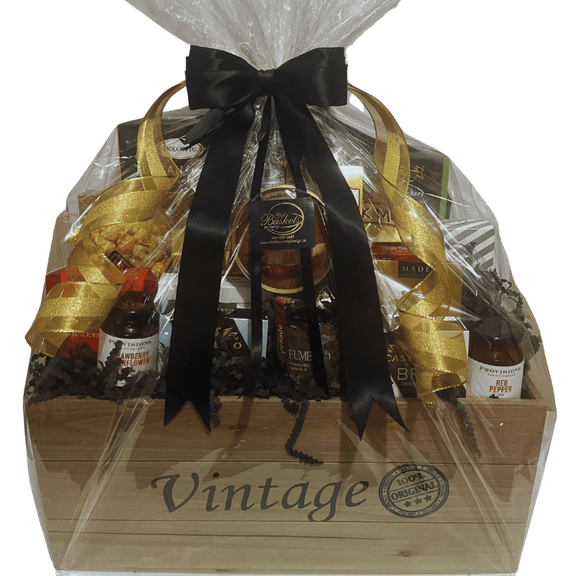 Vintage-style wood crate filled with gourmet snacks, cheese, chocolate, coffee, and savoury treats