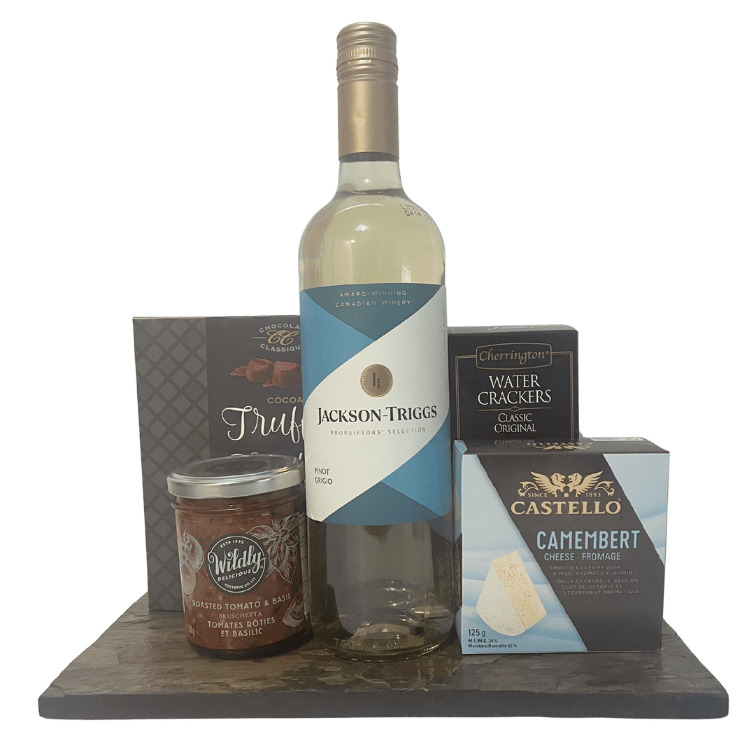 Bottle of Jackson Triggs wine with Camembert cheese, crackers, chocolates and bruschetta on a slate board.