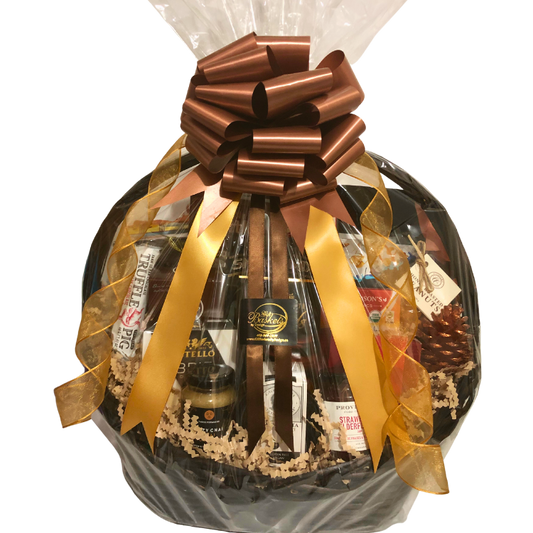 A large wicker gift basket brimming with gourmet treats, shown wrapped in cellophane with elegant gold ribbon.
