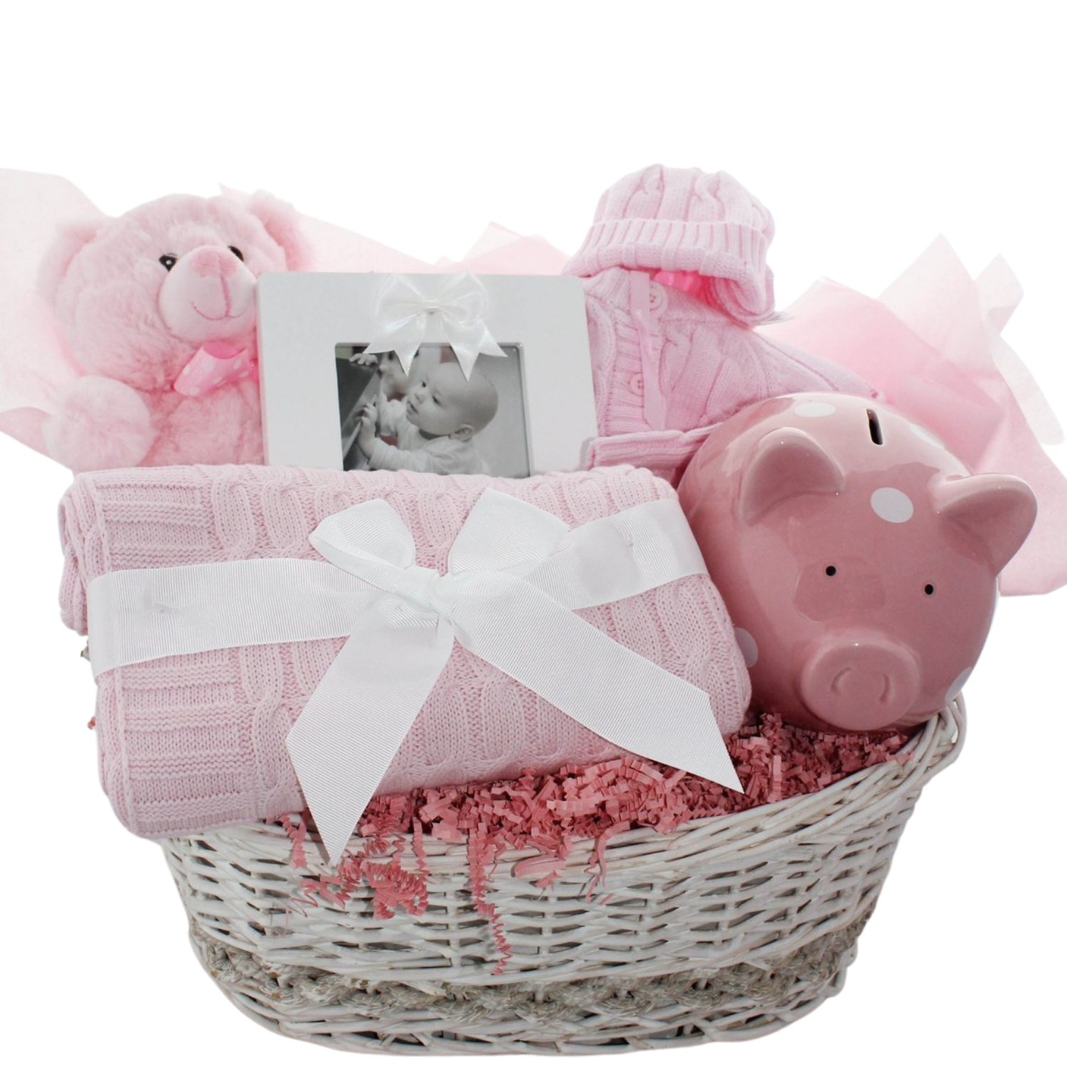 Hello Little One baby gift basket with sweater set, piggy bank, teddy bear, photo frame, and cable knit blanket in a wicker basket, shown in pink